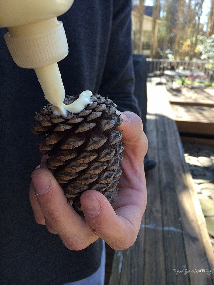 gluing pinecone onto log reindeer