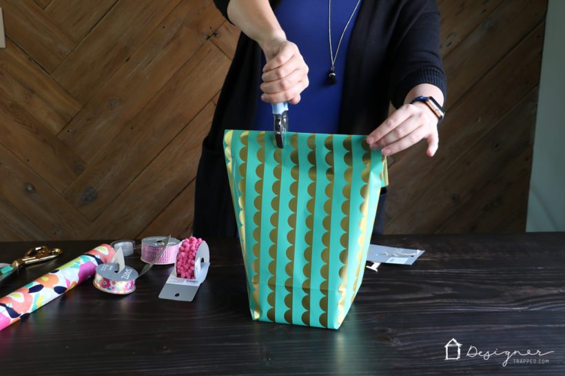 punching hole for ribbon in the top of a DIY bag