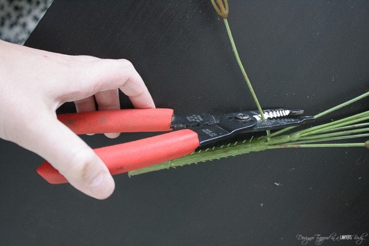 cutting individual stems off silk flower bunch with wire cutters