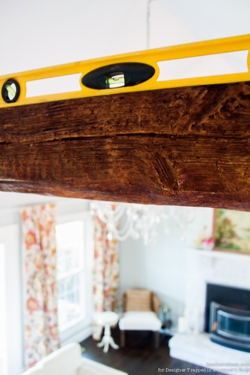 AH-MAZING! Learn how to install faux wood beams. They are affordable and STUNNING. Full tutorial by The Heathered Nest for Designer Trapped in a Lawyer's Body. 