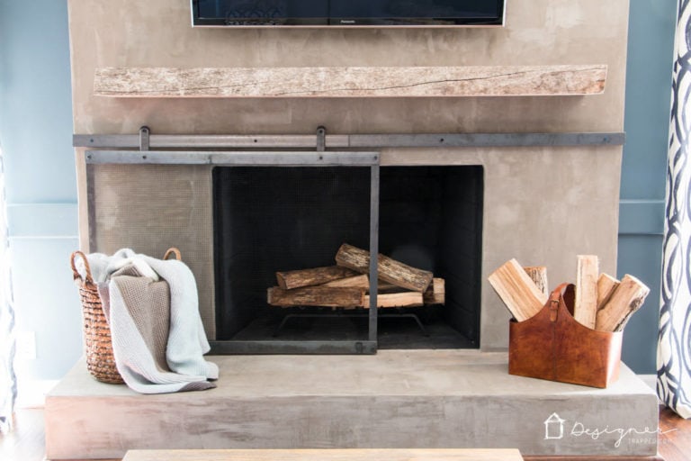 You can create a contemporary fireplace with concrete for less than $100. This full DIY concrete fireplace tutorial will show you exactly how!