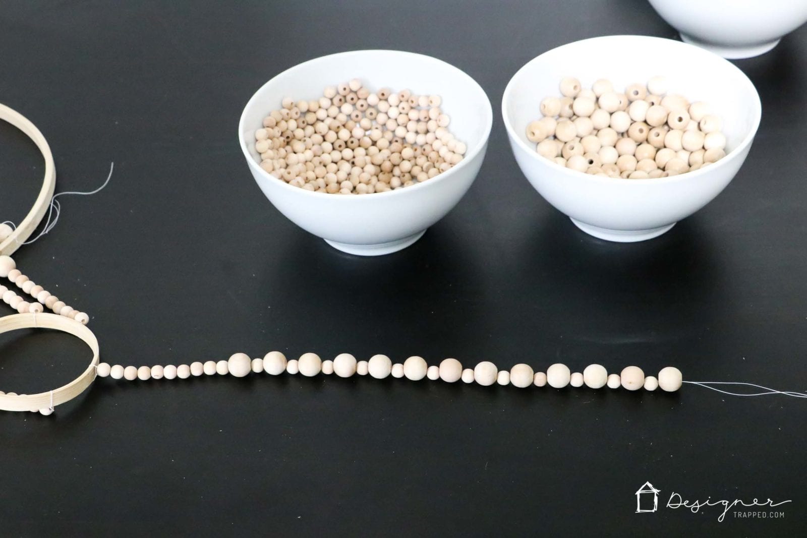 stringing strands of wood beads for DIY chandelier