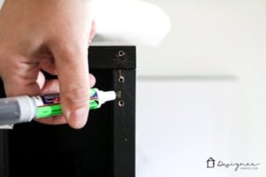 A hand uses a Mohawk 3-In-1 stick to repair IKEA furniture and match the IKEA brand paint.