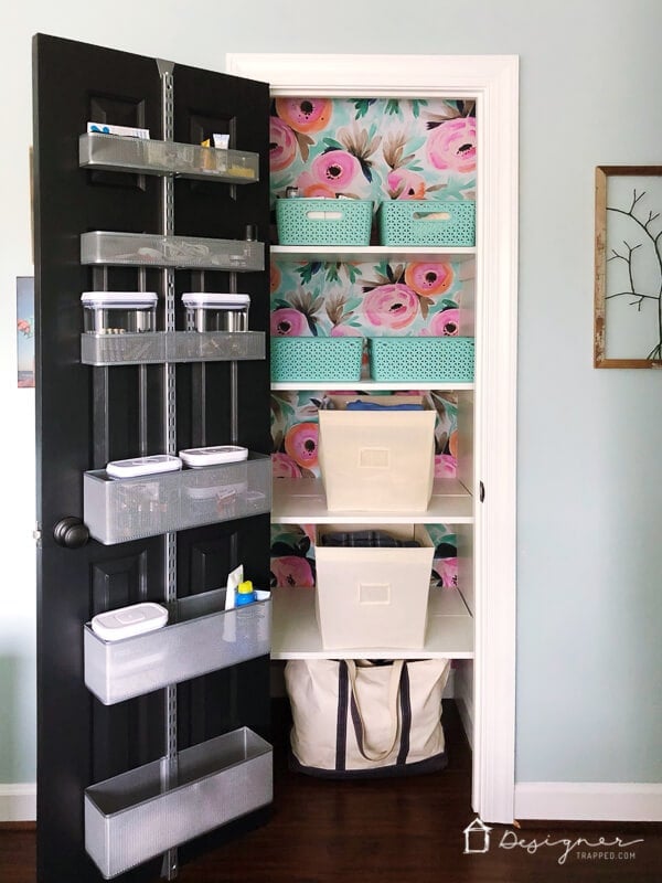 organized linen closet with floral wallpaper