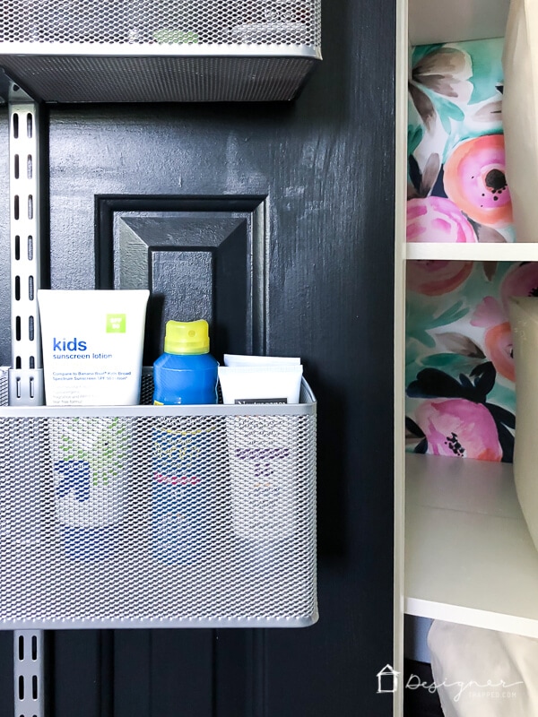 sunscreen stored in door storage basket on linen closet door