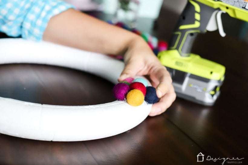 woman making felt ball wreath