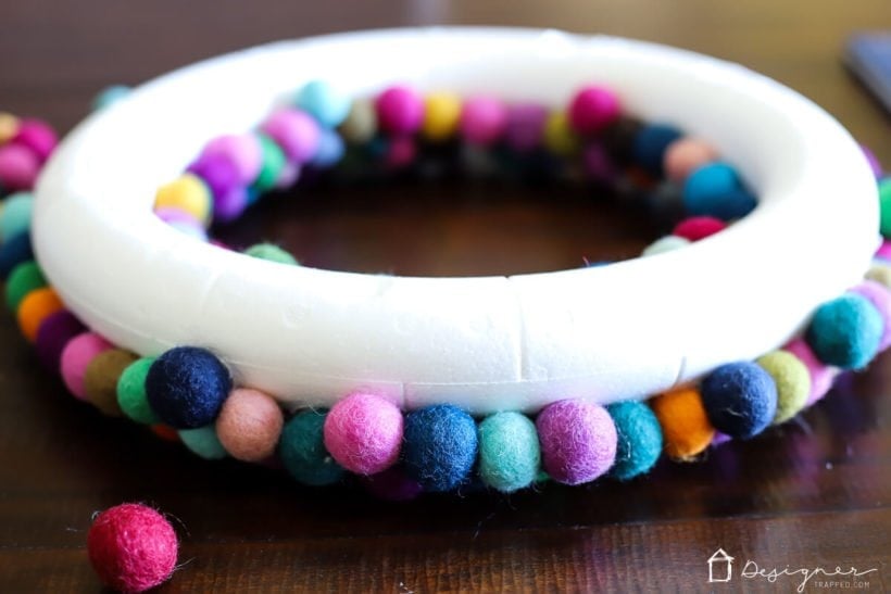 colorful diy felt ball wreath being made