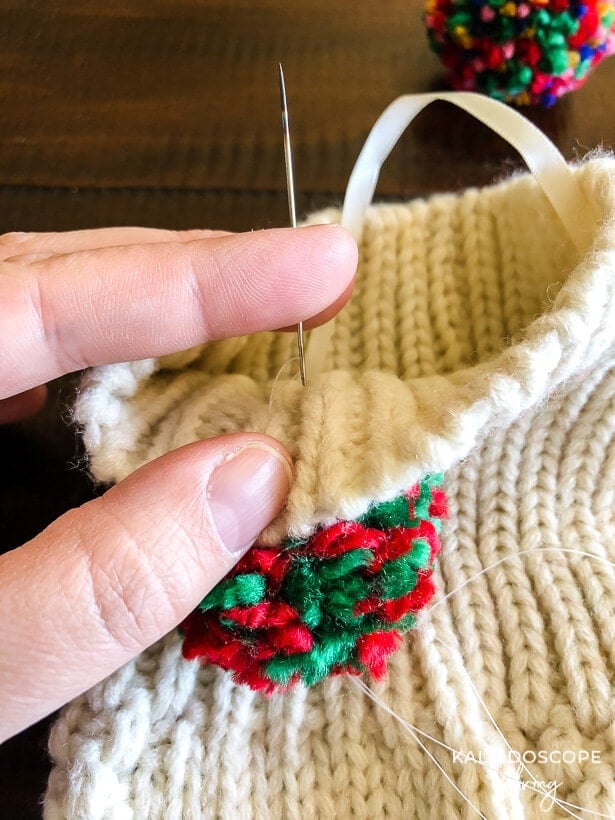 sewing pom pom on stocking