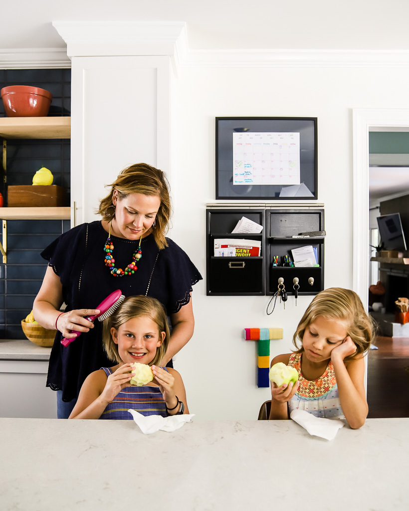 mom and daughters in kitchen with command center