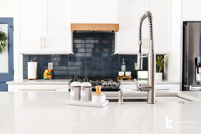 kitchen with white cabinets and navy blue tile backsplash