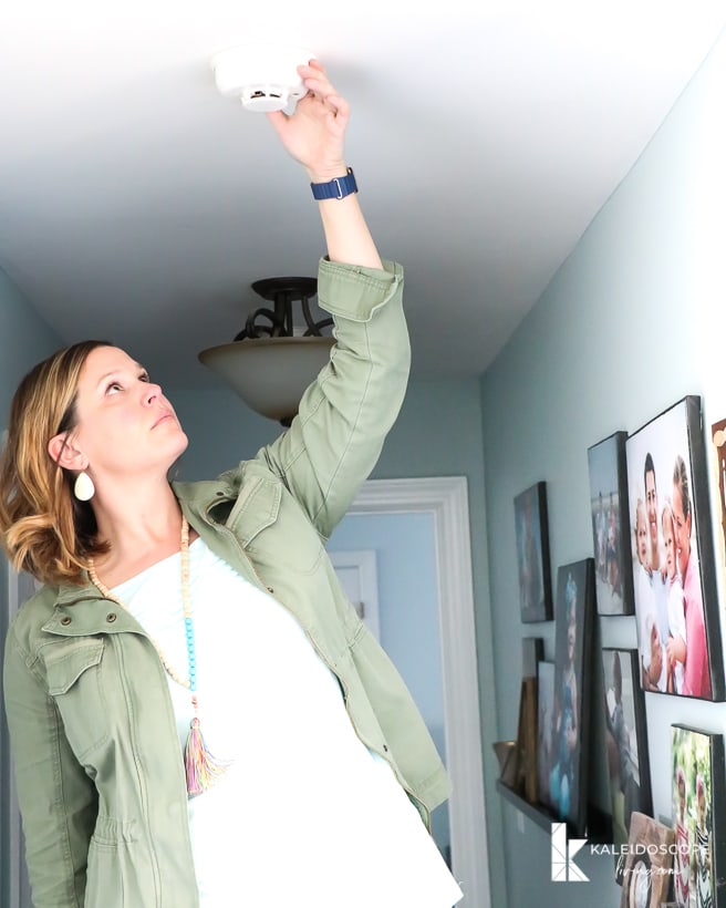 woman testing smoke detector