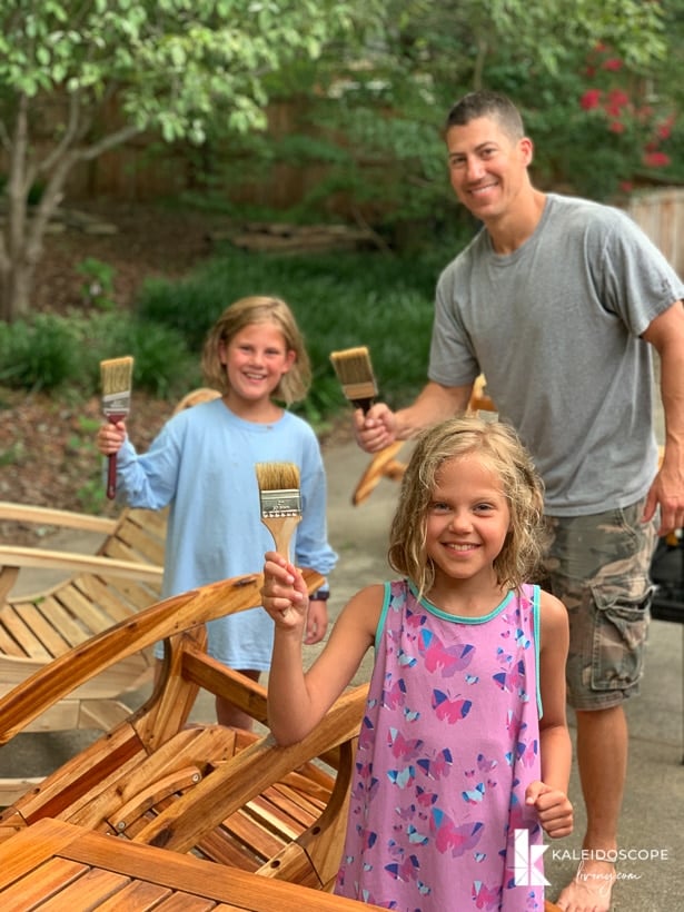 family applying teak oil to outdoor furniture