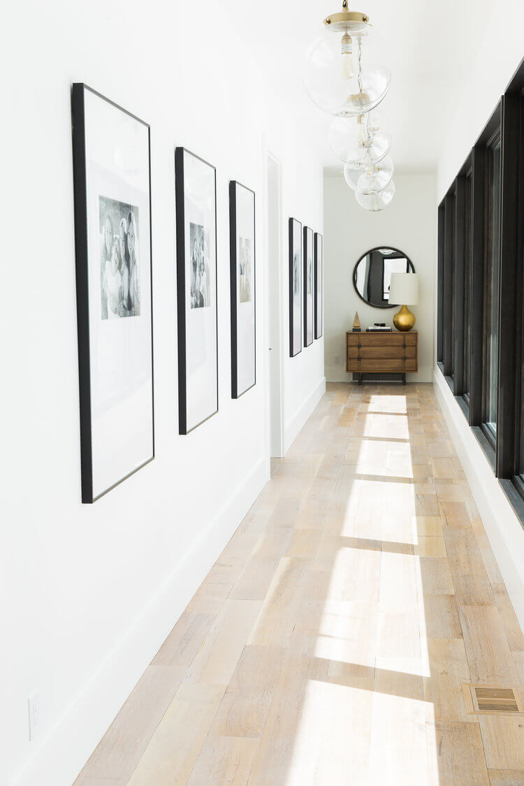 long modern hallway with windows and photographs