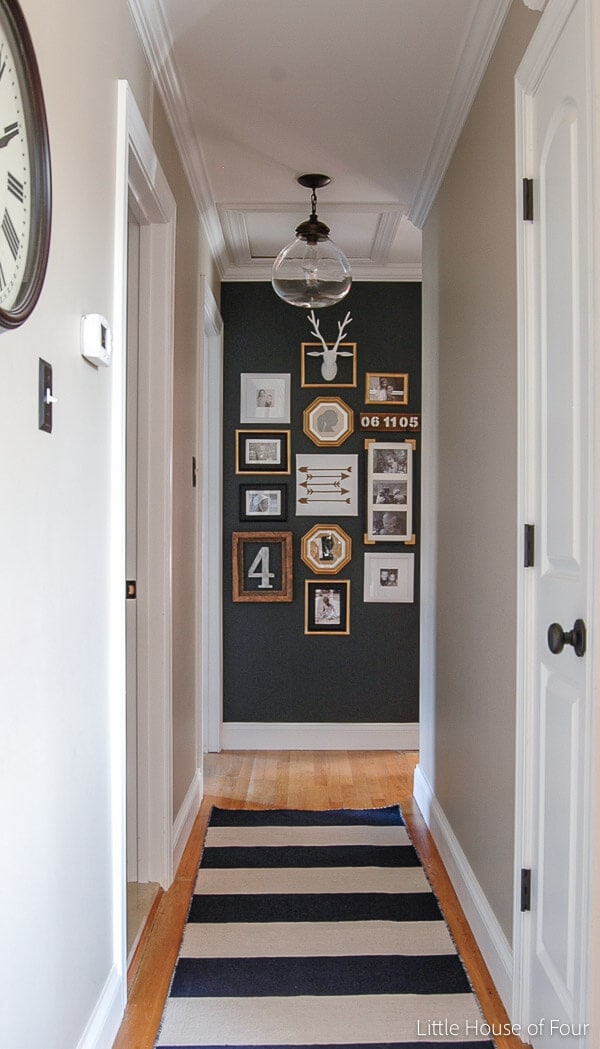 hallway with dark accent wall with gallery wall