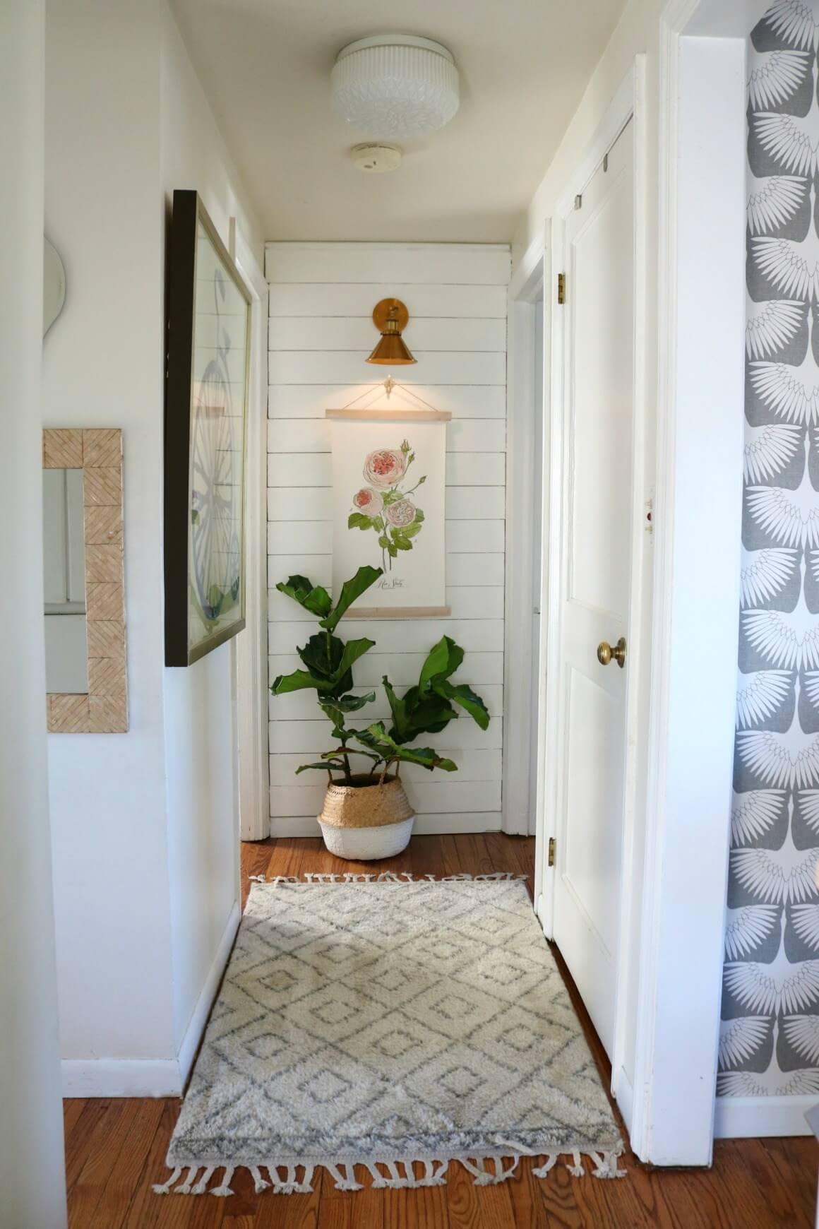 small hallway with shiplap and sconce 