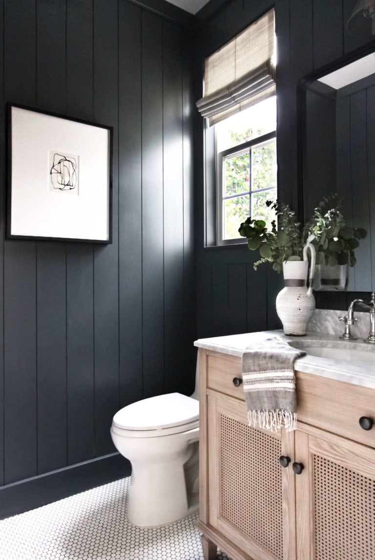 black plank walls and a can vanity in powder room