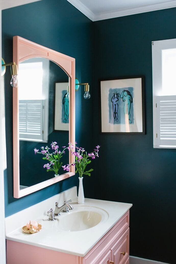 dark blue green bathroom with light pink vanity and mirror