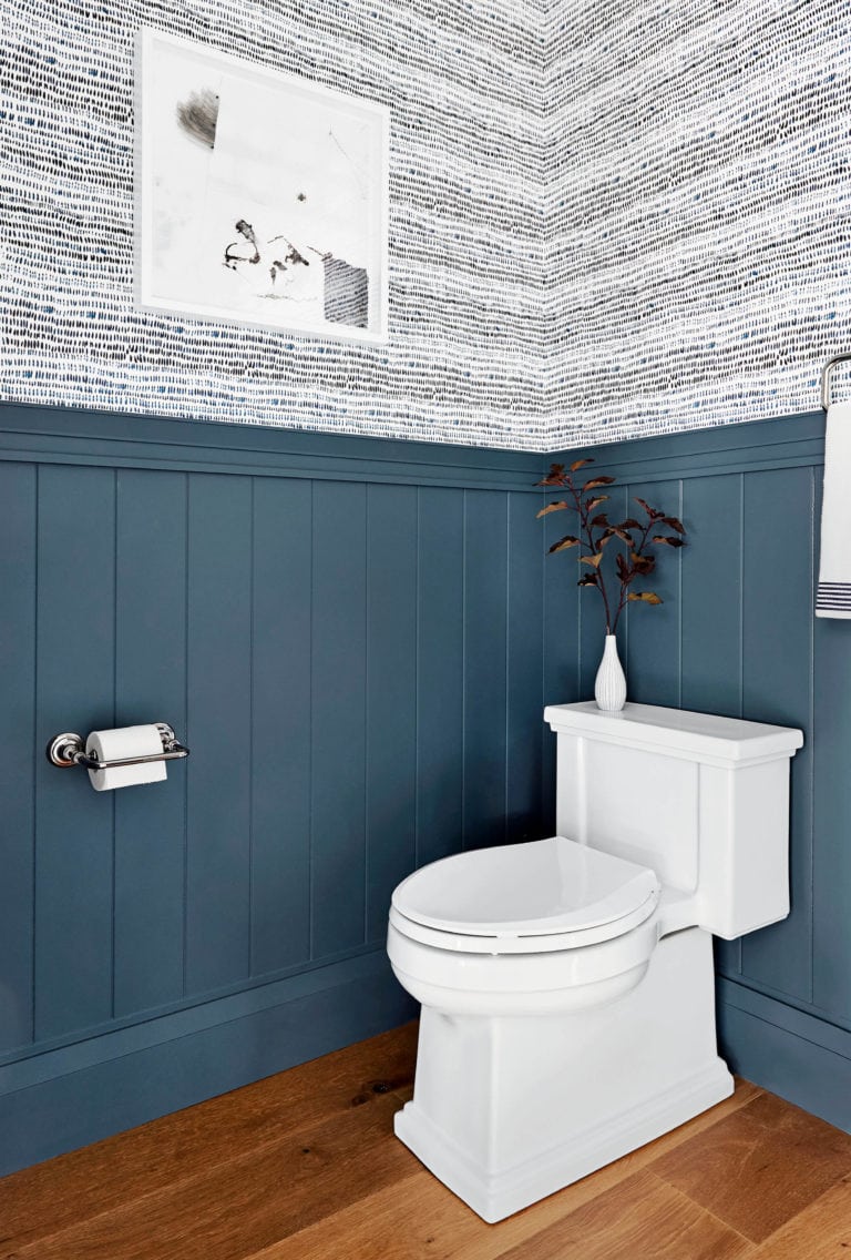 bathroom with blue plan wall on bottom and black and white wallpaper on top