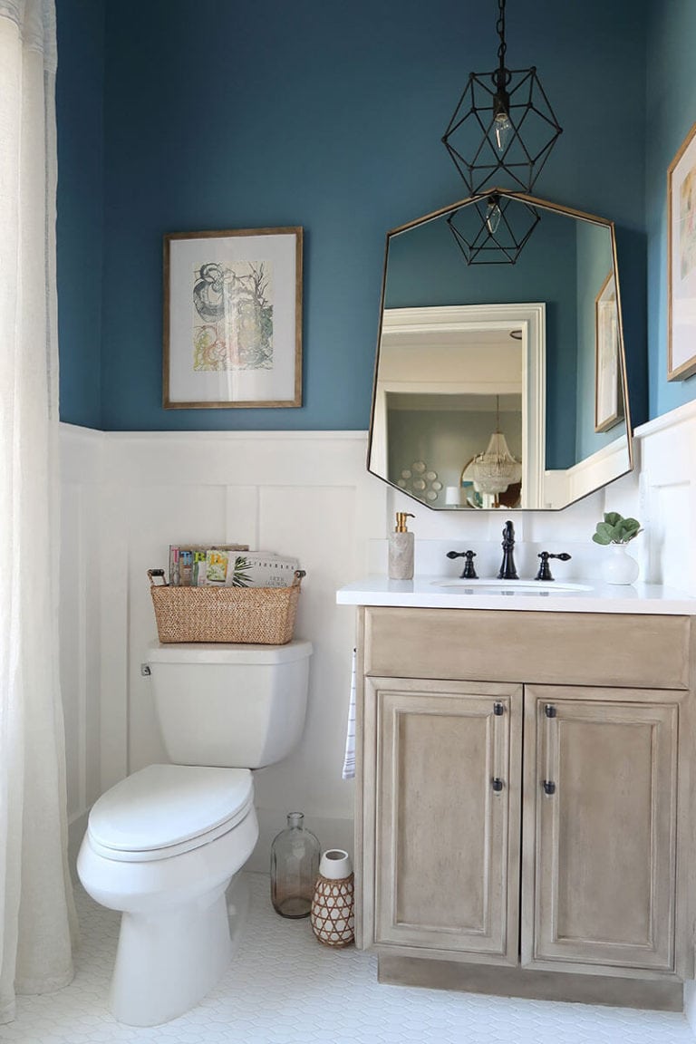 powder room with white bead board and teal walls  with interesting mirror and natural wood vanity
