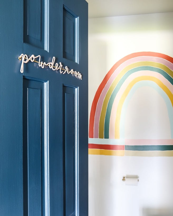 pink powder room sign on dark blue bathroom door