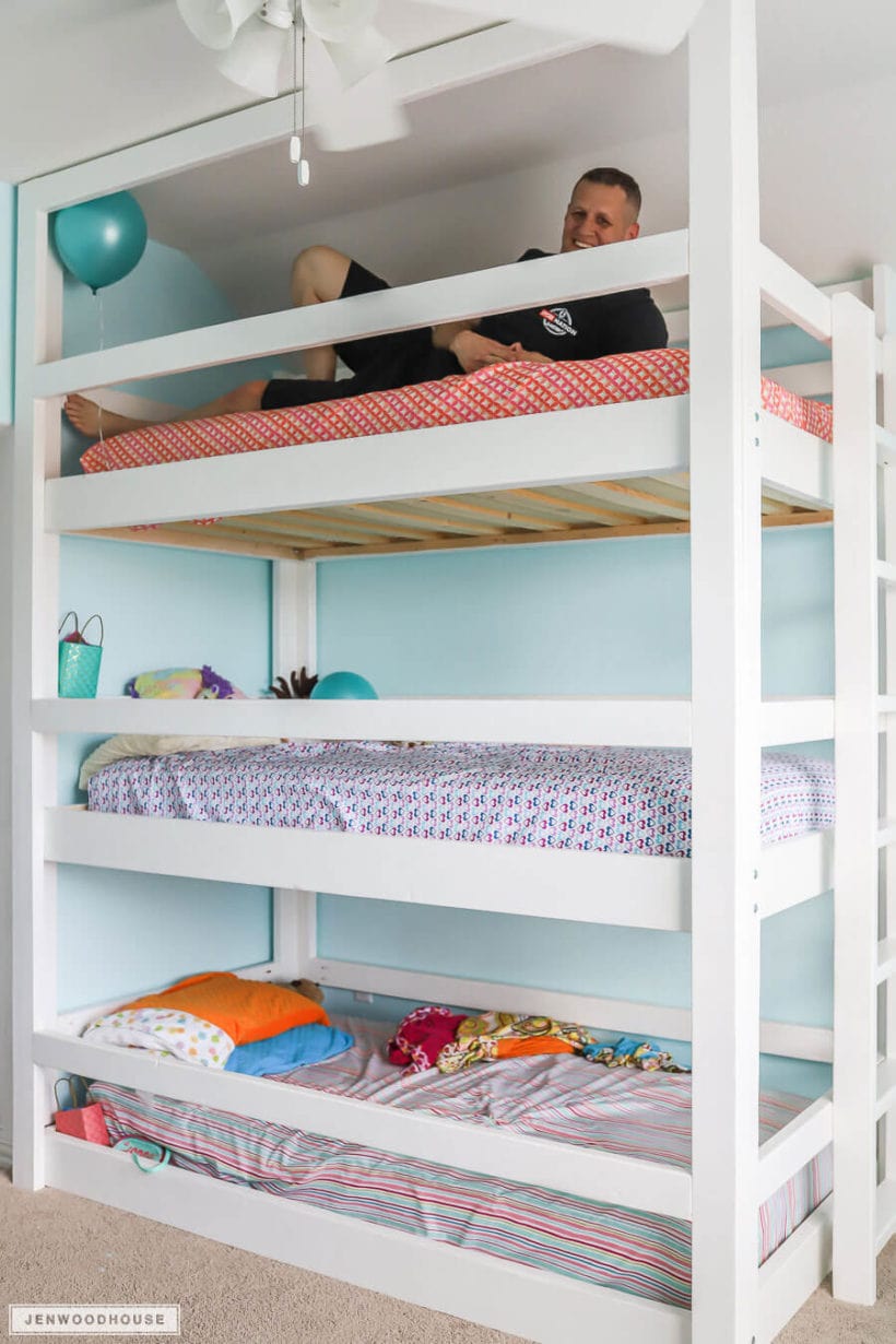DIY triple bunk beds with man laying on the top one