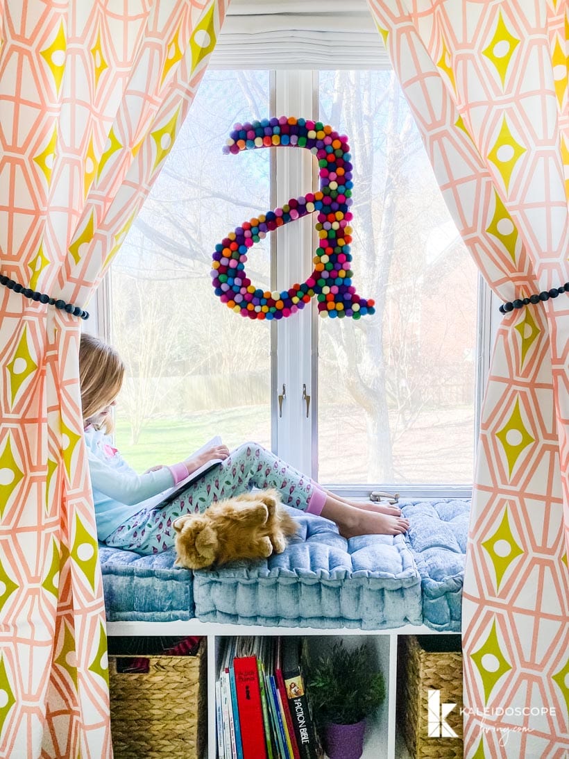reading nook framed by curtains in colorful girl's bedroom