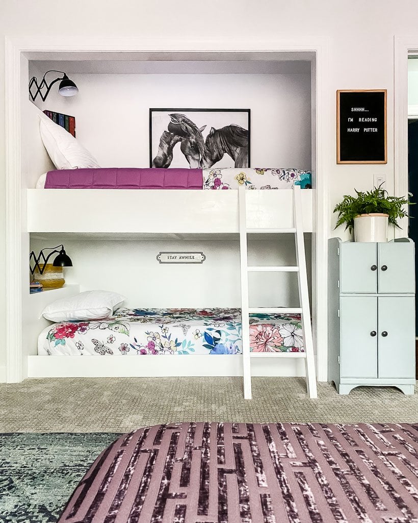 white bunk beds built into closet nook with flowered comforters 