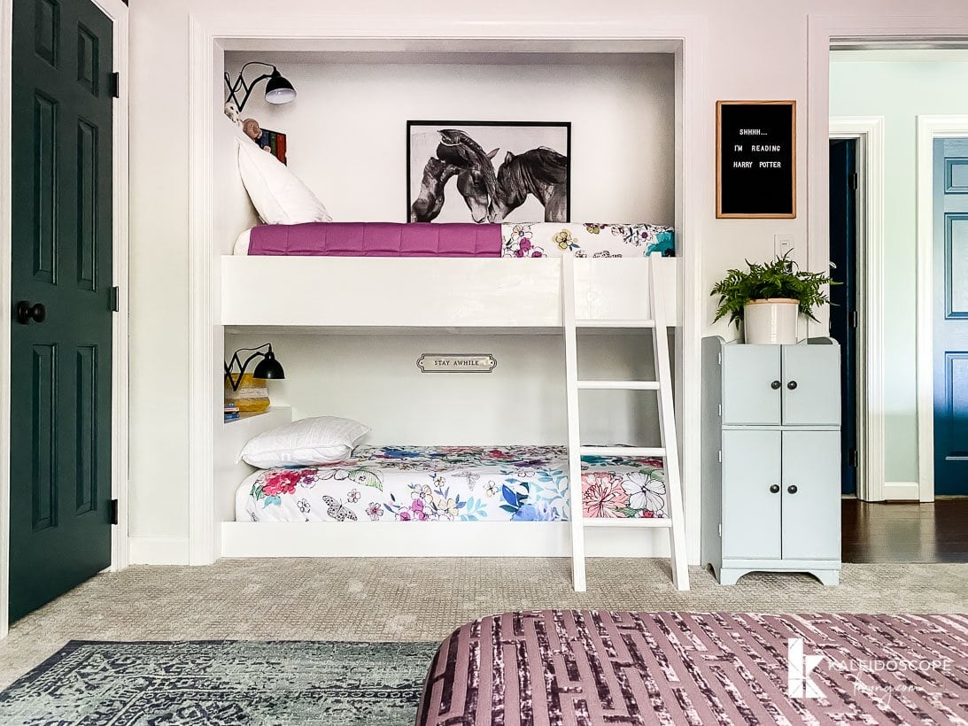 A girl's bedroom with built-in bunkbeds in a closers nook. 