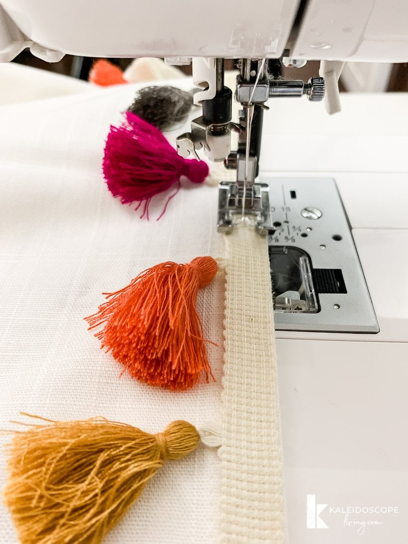 sewing colorful tassel trim on curtains