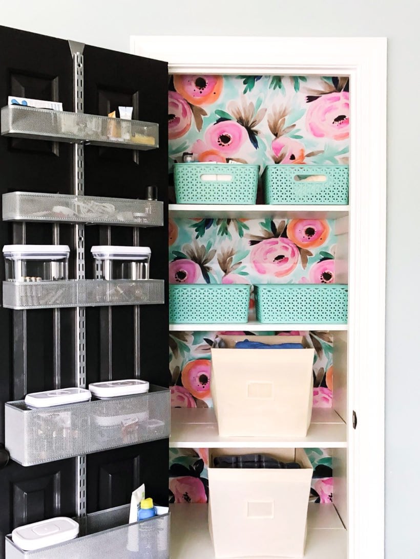 wallpapered linen closet with bins