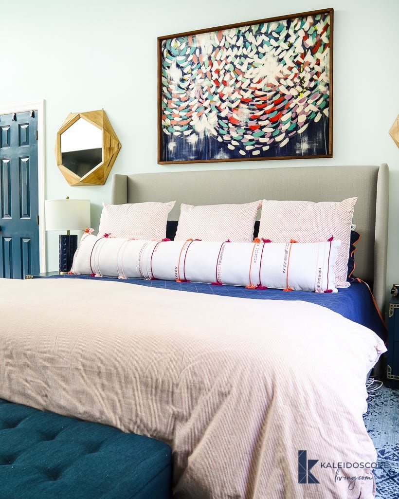 oversized lumbar pillow on king-size bed in blue and pink bedroom