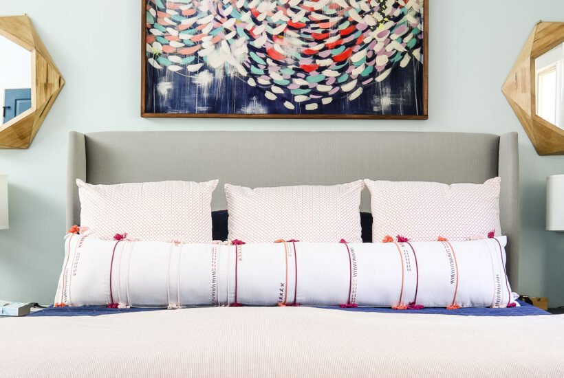 oversized DIY lumbar pillow on king bed in coral and blue bedroom