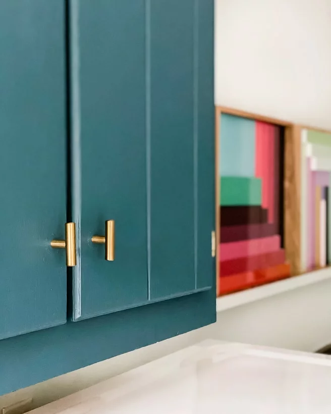 teal painted cabinets with brass hardware