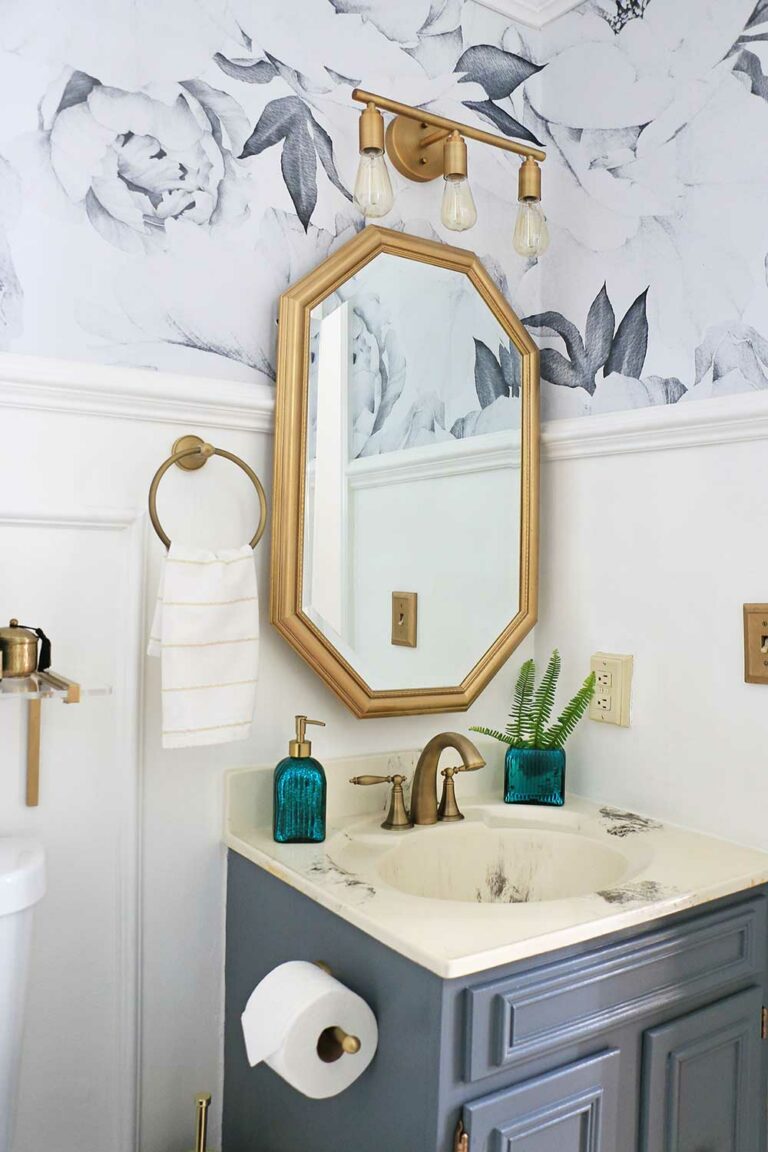 powder room with gold mirror and fixtures and black and white floral wallpaper
