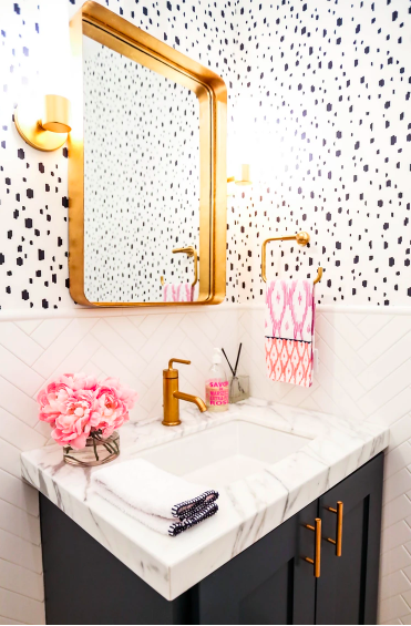 powder room with gold finishes and black and white wallpaper