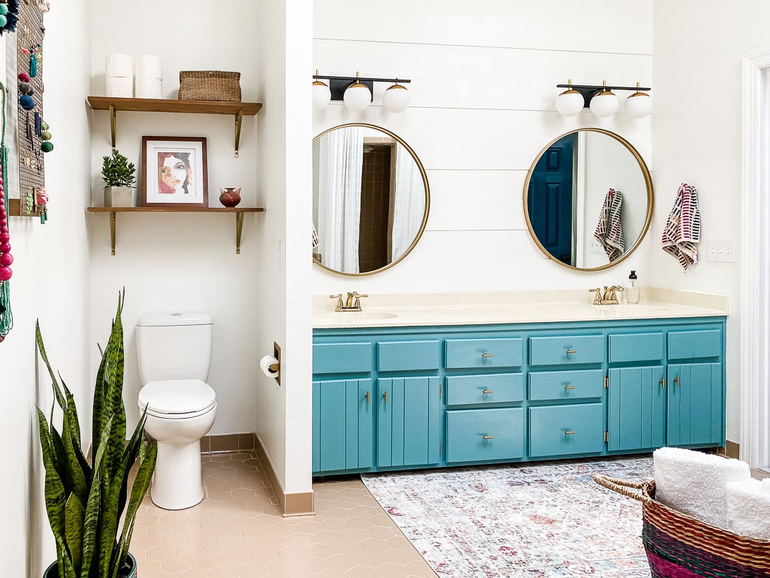 turquoise vanity with plank wall and round mirrors