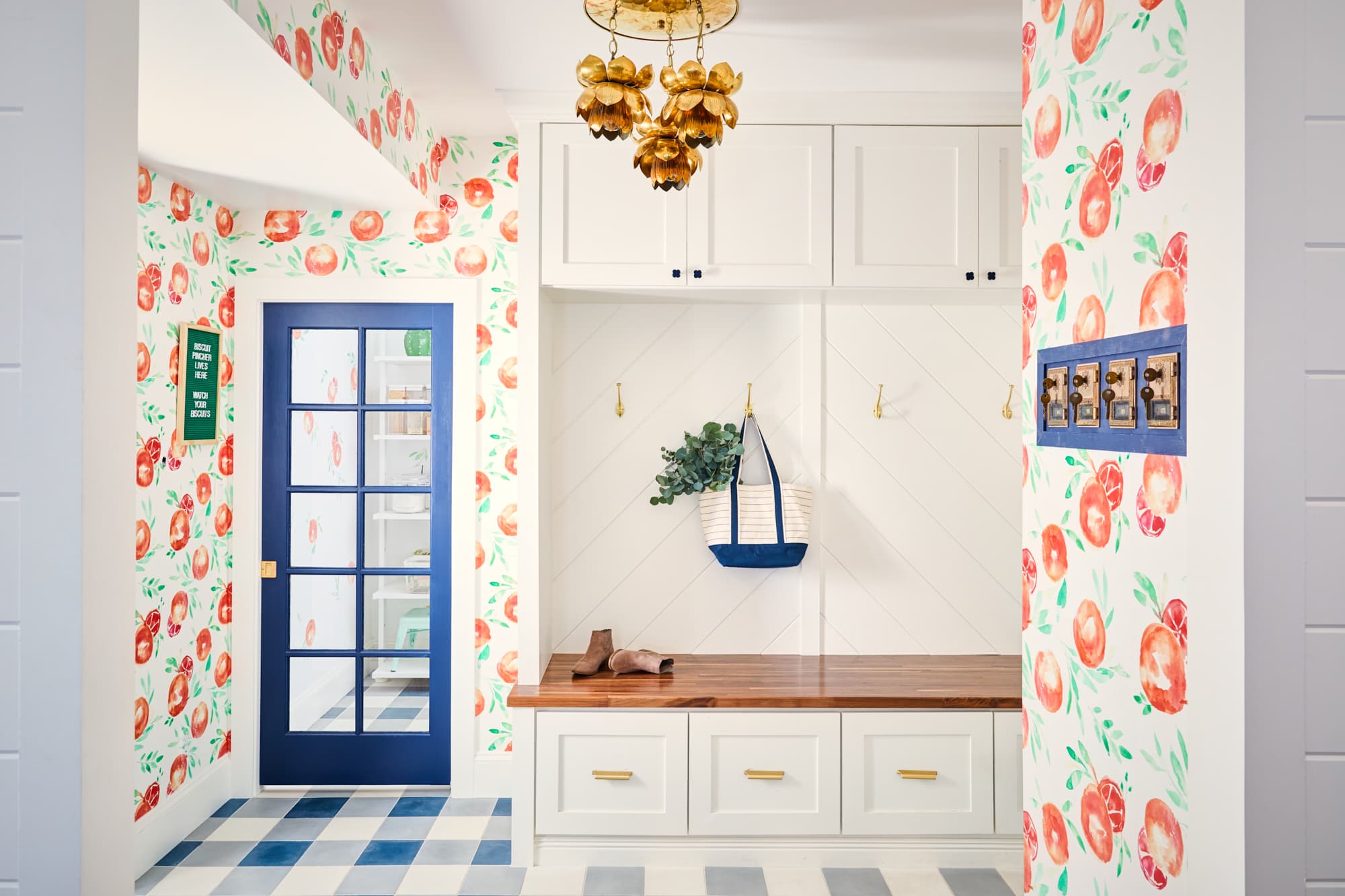 wallpapered mudroom with blue door