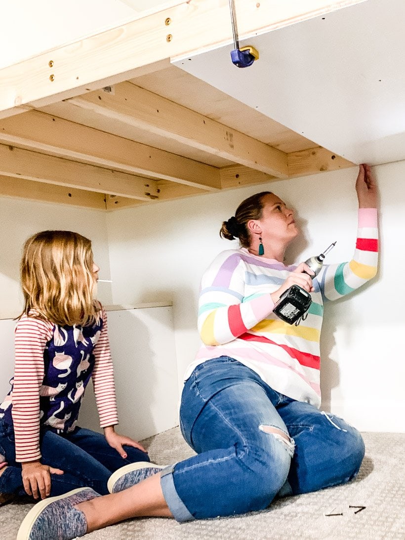 mom and daughter building built-in bunk bed together