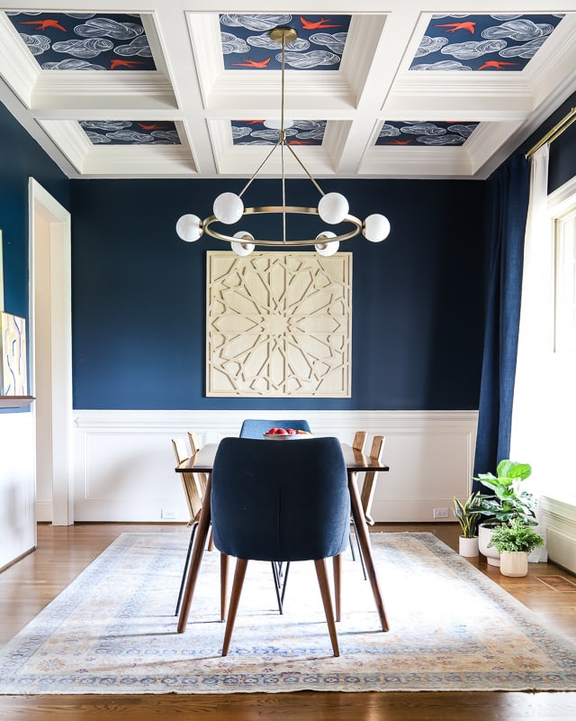 navy blue dining room with wallpaper ceiling