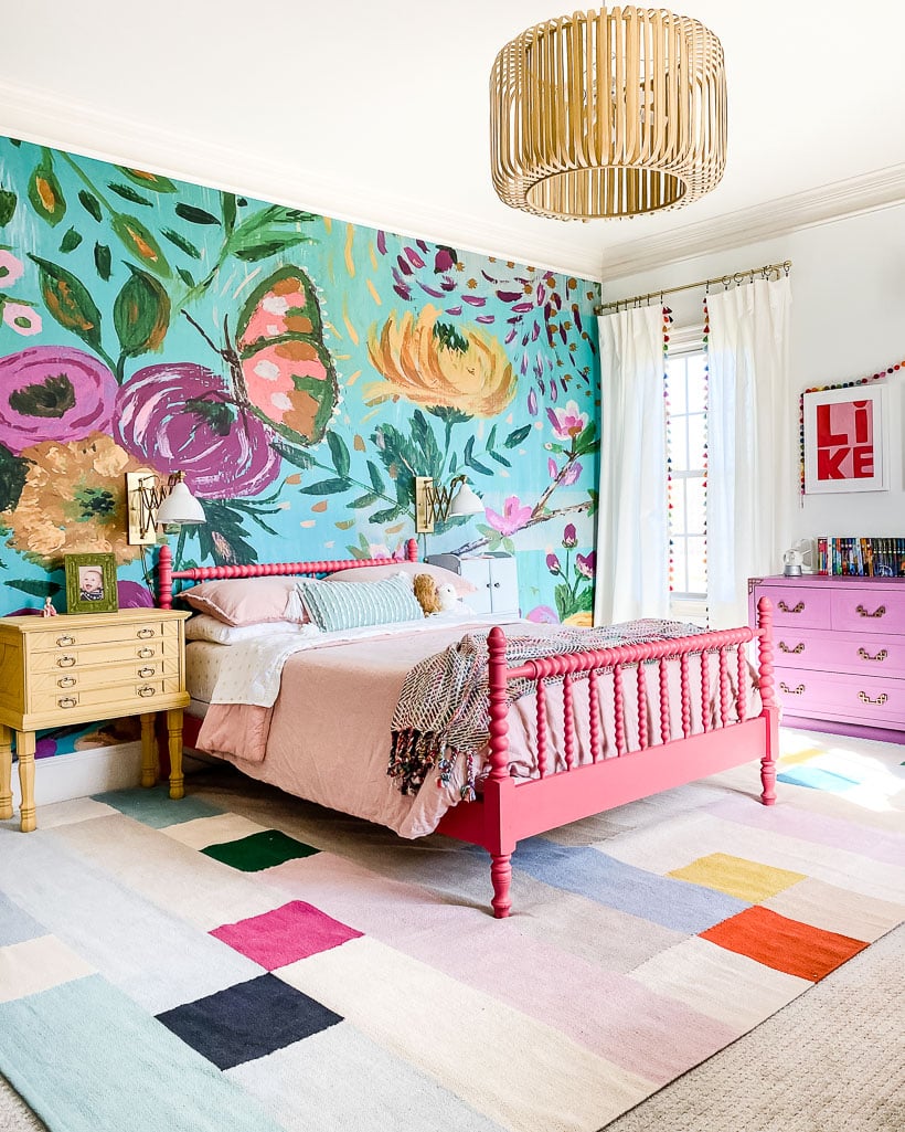 colorful bedroom mural with flowers and butterfly with coral vintage bed and color blocked rug