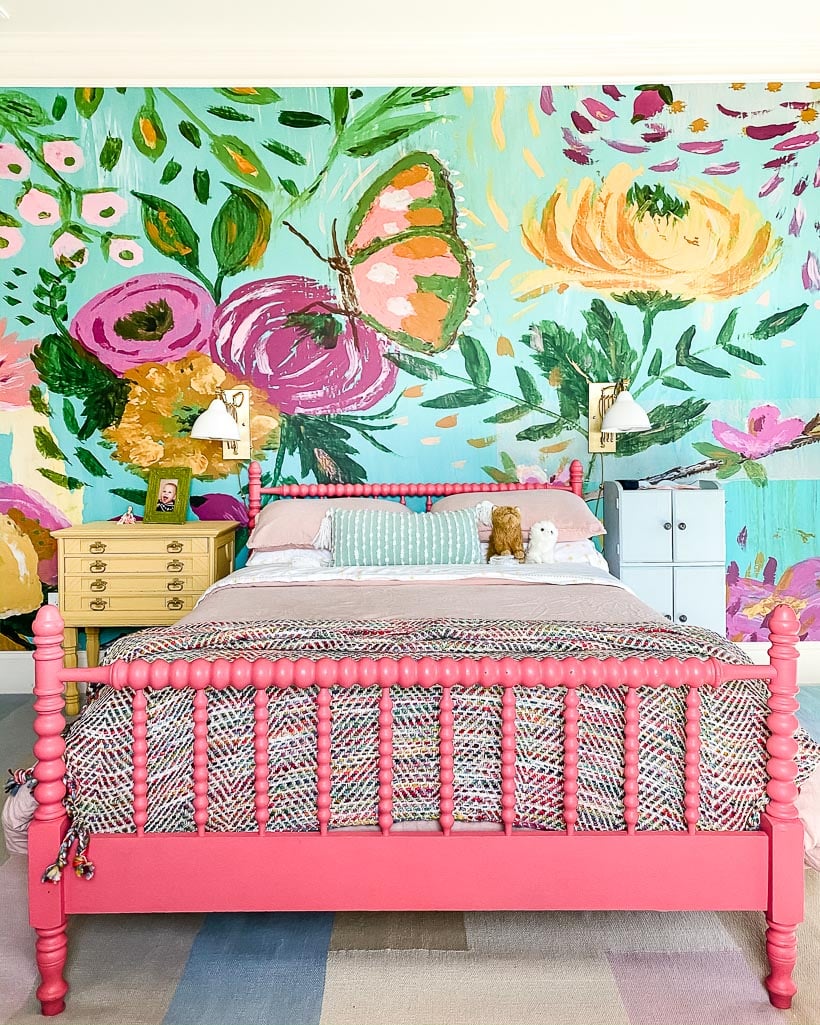 Colorful girls' room with painted furniture, flowered wall mural and colorful bedding.