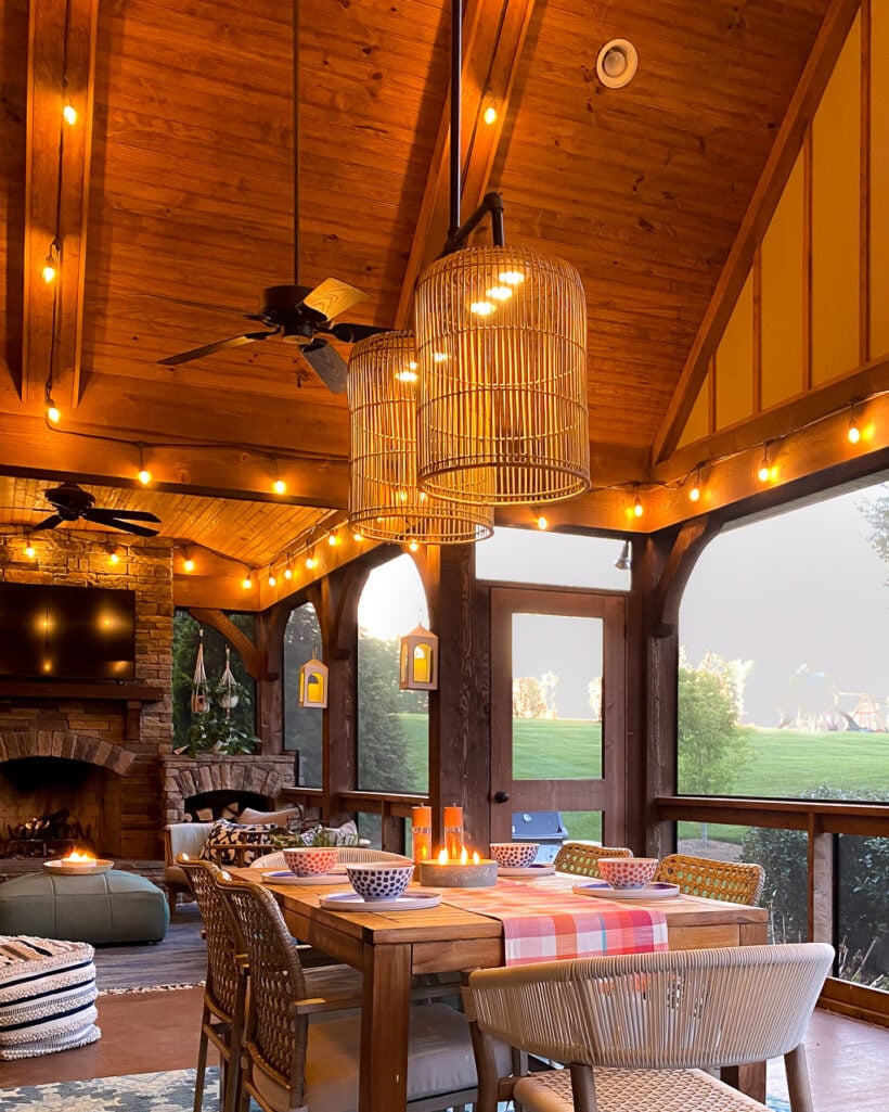 colorful outdoor dining area in screened-in-porch with vaulted ceilings and DIY outdoor chandelier