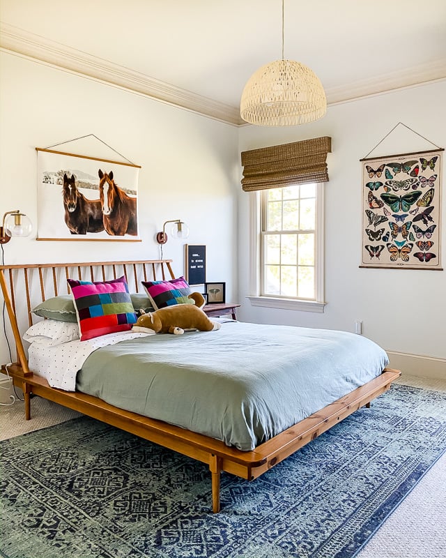 blue and teal area rug under queen bed and over carpet in girl's bedroom