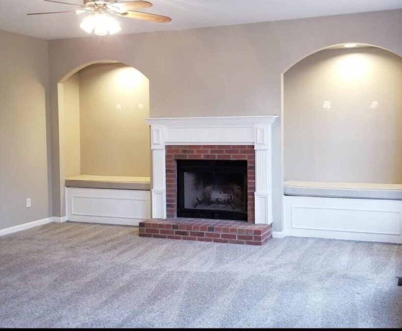 beige family room with brick fireplace before makeover