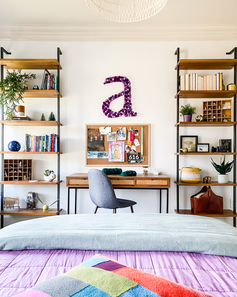 girl's bedroom with desk and bookshelves and large wall letter hanging on wall