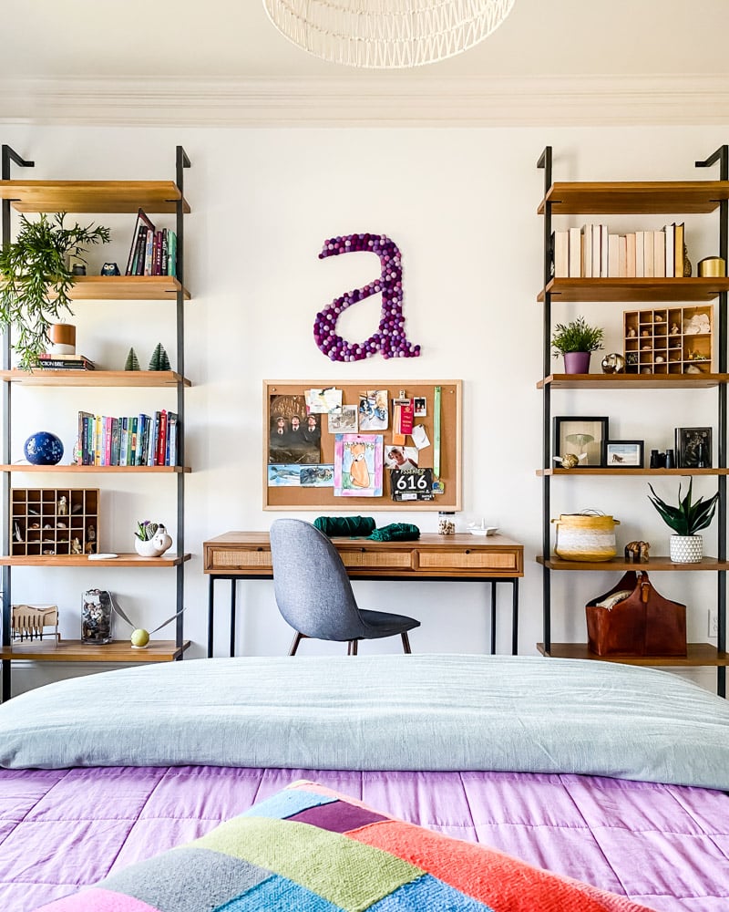 wood desk and wall mounted wood shelves in girl's bedroom