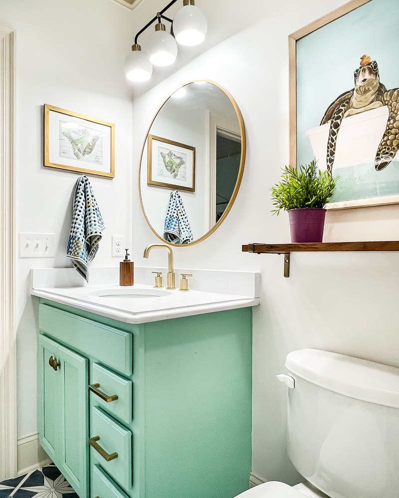 updated light fixture in girls' bathroom with green vanity
