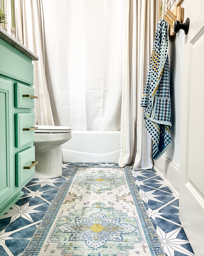 bathroom with star tiled floor and overdyed vintage runner 