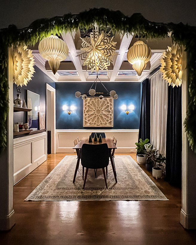 navy blue dining room decorated for Christmas with paper lanterns by Tasha Agruso of Kaleidoscope Living