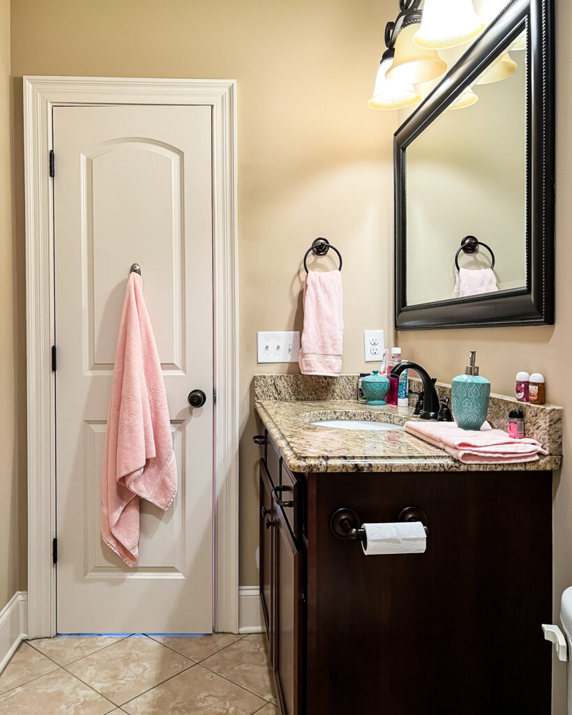 outdated bathroom with brown walls and dark wood vanity before makeover